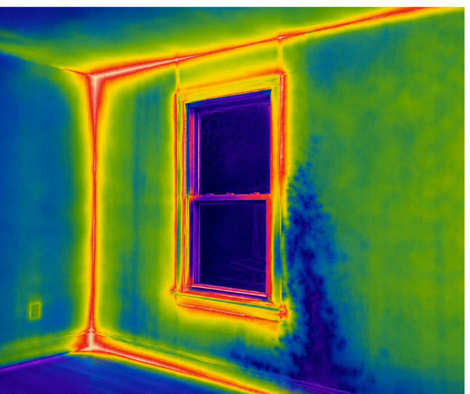 Thermal image of a corner room with a window; warm yellow/red heat around the window frame and edges, cooler blue-green walls.